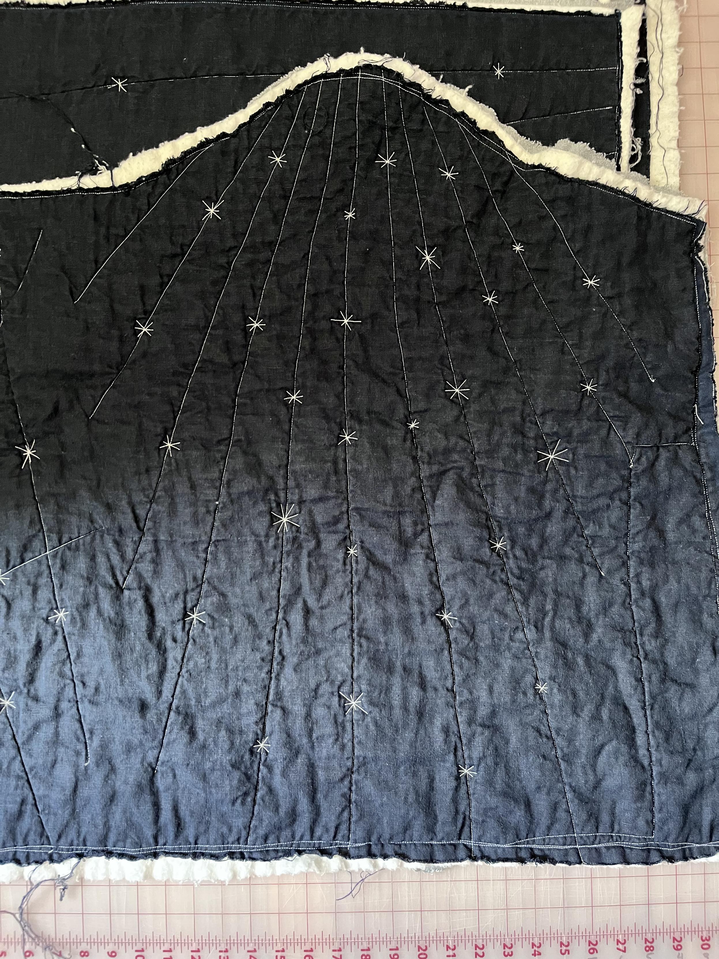 After quilting with reflective thread and washing. The linen is now *very* rumpled. Little asterisk stars have replaced the hash marks.