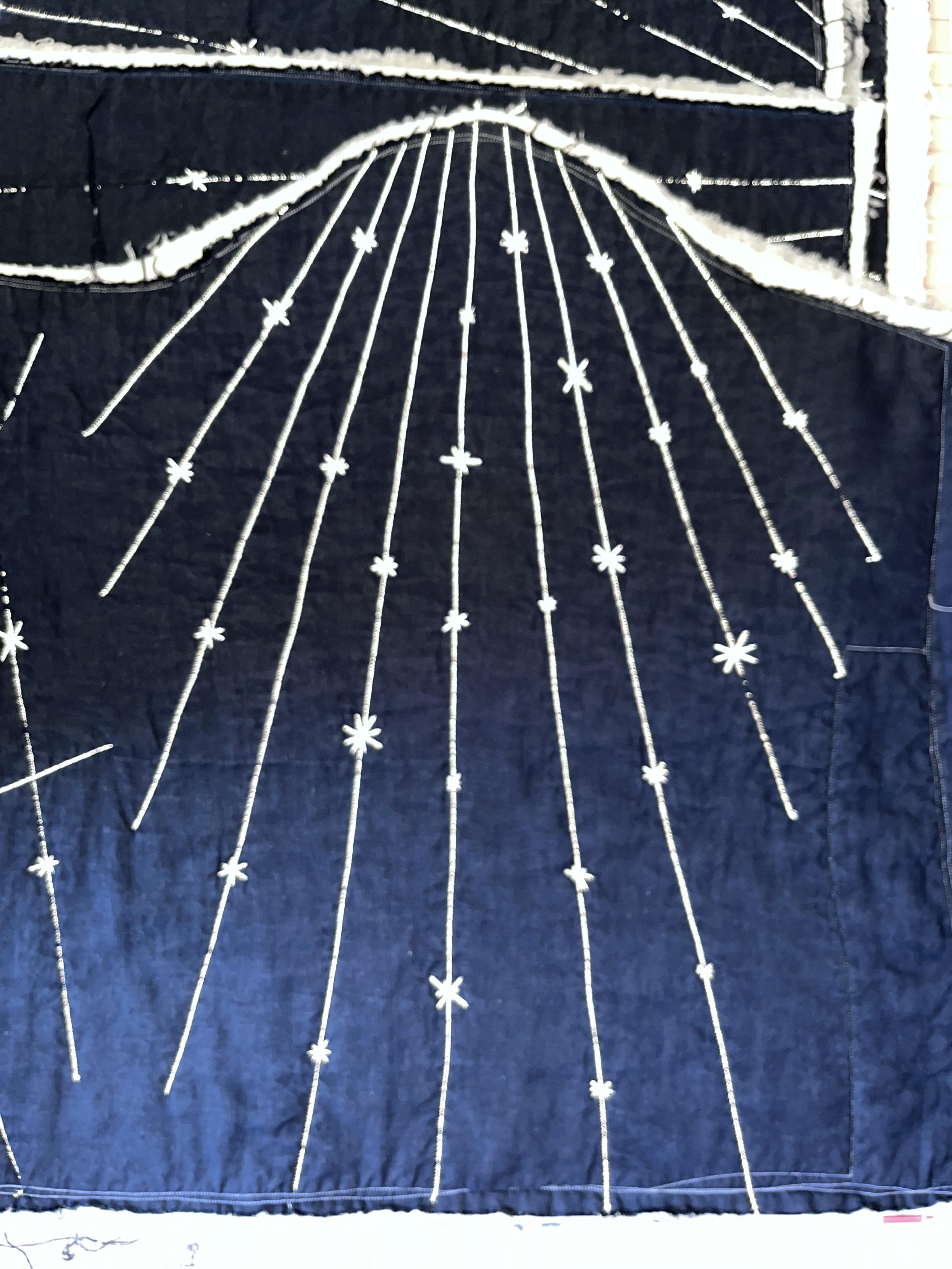 After ironing, taken with flash. The radial lines and stars are VERY BRIGHT AND SILVERY against the navy linen.